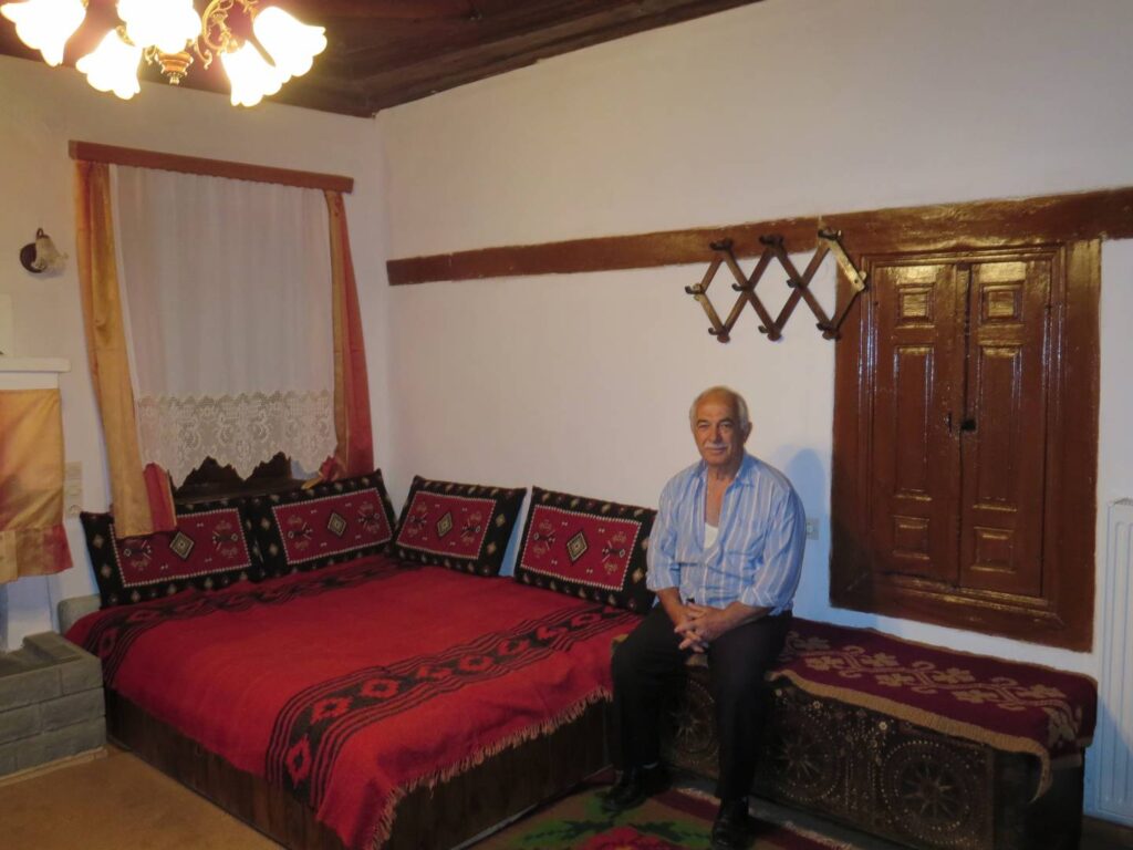 The owner sitting on the couch in his traditional home, Kapesovo