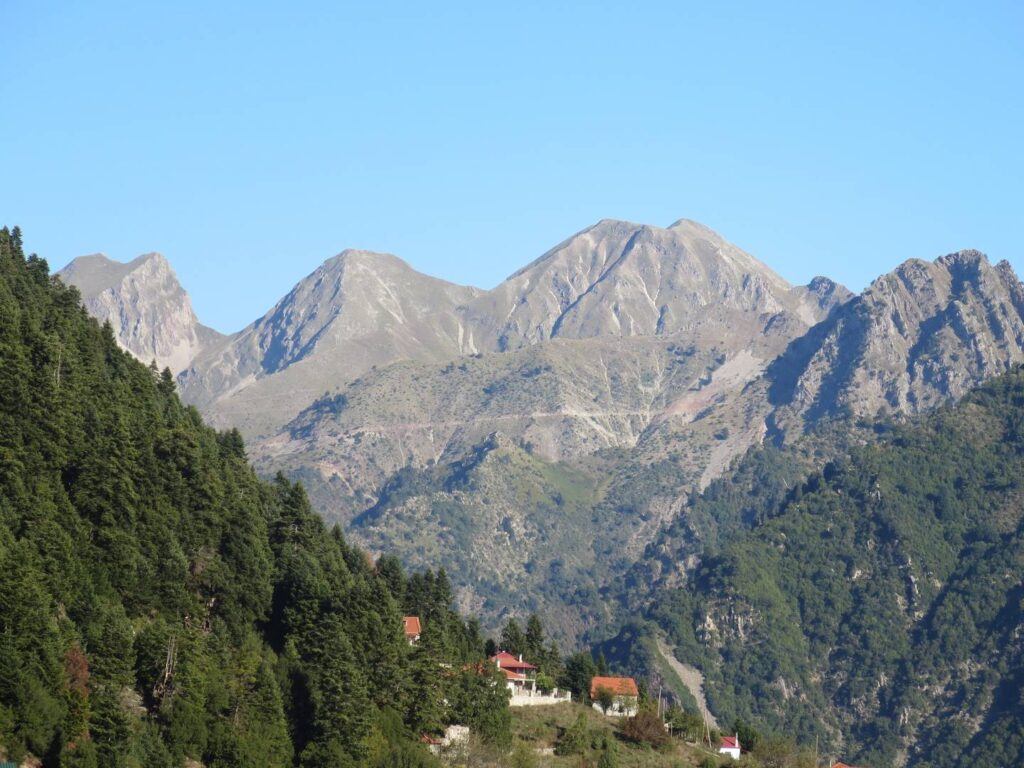Steep rocky peaks of Delidhimi , with the scattered houses of Epiniana and pine forest in the foreground