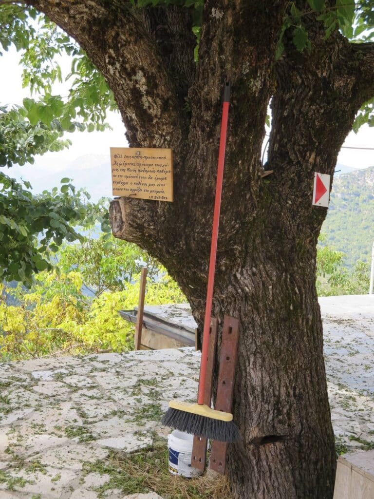 Broom and plea to keep the place tidy hung up on a tree in the Matsouki monastery courtyard